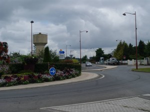 The Tilly Junction/D 675 towards Caen in 2014. Note the distinctive water tower on the left