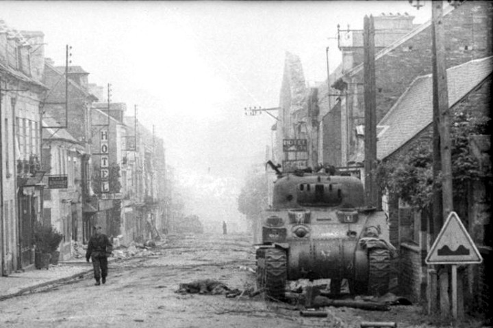 The OP Sherman belong to Maj. Dennis Wells on the Rue Georges Clémenceau. Note the wooden “gun” on the ground in front